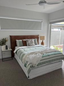 Un dormitorio con una cama grande y una ventana en Golf Fronted on the 6th Fairway, en Yarrawonga