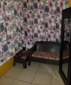 una camera con divano e parete con fiori di Rouse Homestays a Couva