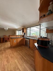 WoollamiaにあるAt holiday houseの大きな窓、ウッドフロアの広いキッチンが備わります。
