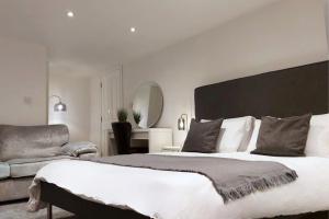2 Bedroom City Centre Duplex Apt في بريستون: غرفة نوم بسرير كبير وأريكة