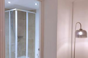 une douche avec une porte en verre à côté d'une lampe dans l'établissement 2 Bedroom City Centre Duplex Apt, à Preston