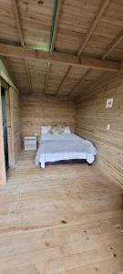 1 dormitorio con 1 cama en una habitación de madera en Kuyana Glamping, en Cali