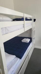 a bedroom with two bunk beds with a blue mattress at Husky 19 Beautifully Appointed Apartments - GREAT LOCATION - in the heart of Husky in Huskisson