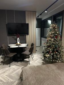 a living room with a christmas tree and a table and chairs at modern studio @ city center in Rovaniemi