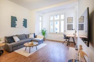 uma sala de estar com um sofá e uma mesa em Südstadt-Oase Komfort mit 2 SZ und Balkon em Koblenz