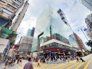 uma multidão de pessoas atravessando uma rua em uma cidade em International Metro Guest House em Hong Kong