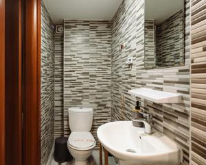 uma casa de banho com um WC branco e um lavatório. em Floret Apartment em Tessalônica
