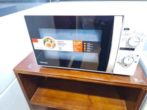 a microwave oven sitting on top of a wooden table at International Metro Guest House in Hong Kong