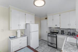 a kitchen with white cabinets and a stove and refrigerator at 3 Bd House, Walkable To Bart, Free Parking, Views in Daly City