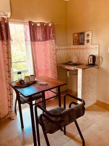 帕索德洛斯利布雷斯的住宿－HOSPEDAJE LA NORMA，厨房配有桌子、桌子和椅子