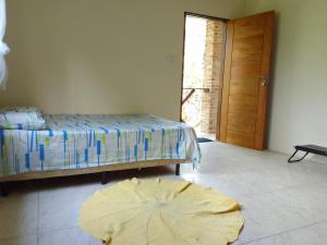 a bedroom with a bed and a wooden door at Suítes Recanto Dos Passarinhos 2 in Ubatuba
