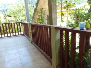 a balcony with a wooden railing and a tree at Suítes Recanto Dos Passarinhos 2 in Ubatuba