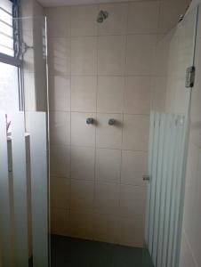 a shower with a glass door in a bathroom at Habitación acogedora in Quito