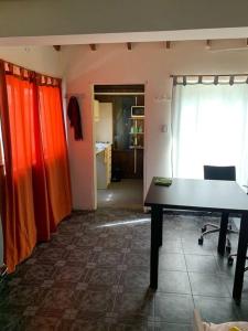 烏斯懷亞的住宿－Leandro´s house，一间橙色窗帘和桌子的房间