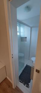 a bathroom with a glass shower with a toilet at Ap 154 Balneário Piçarras in Piçarras