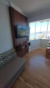 a living room with a couch and a flat screen tv at Ap 154 Balneário Piçarras in Piçarras