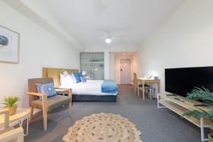 um quarto de hotel com uma cama e uma televisão em 'Déjà Blue' Knuckey's King Suite Comfort em Darwin