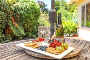 een tafel met een bord eten en een fles wijn bij Top of the Lake - Taupo in Taupo