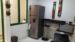 a stainless steel refrigerator in a room with a desk at Loft urbano apartamento in Salento
