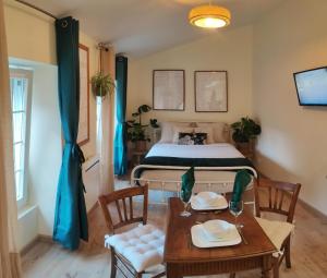 1 dormitorio con 1 cama, mesa y sillas en La Green Room en Poitiers