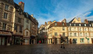 a city street with buildings on a cobblestone street at La Green Room in Poitiers
