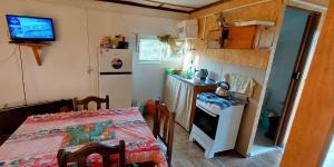 uma pequena cozinha com uma mesa e uma cozinha com um frigorífico em Merencere La Esmeralda, Monoambiente a pasos de la playa em La Esmeralda