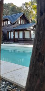 una casa con piscina frente a una casa en La Secreta en Villa Giardino