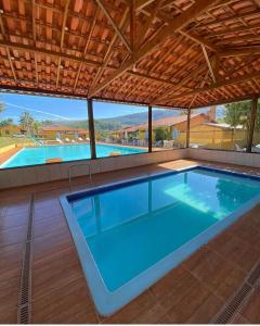 uma grande piscina numa casa com telhado em Pousada Engenho Velho em Serra do Cipo