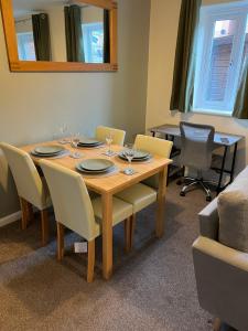 uma sala de jantar com mesa e cadeiras em Modern Semi detached in a quiet location, Driveway parking em Ewloe