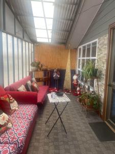 a living room with a red couch and a table at Hospedaje Sra Jenny in Puerto Montt