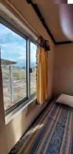 um quarto com uma janela com uma cama em frente em Merencere La Esmeralda, Monoambiente a pasos de la playa em La Esmeralda