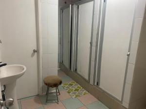 a bathroom with a sink and a shower and a stool at Hospedaje Sra Jenny in Puerto Montt