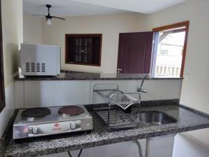 a kitchen counter with a stove and a sink at Casa Azul Perequê in Ilhabela