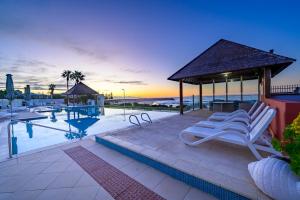 a swimming pool with a gazebo and lounge chairs at Sea Side 104 in Mandurah