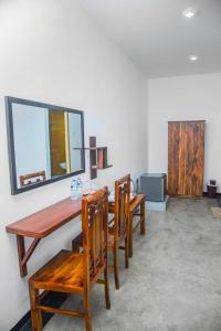 uma sala de jantar com uma mesa de madeira e cadeiras em Hanka Villa -Ambalangoda em Ambalangoda