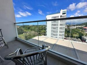 a balcony with a chair and a view of a building at Aru Suites HOMESTAY WIFI,Carpark,24h Check in,Water Filter by R2 Residence in Kota Kinabalu