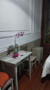 um vaso de flores numa mesa num quarto em Dante y compañia em Buenos Aires