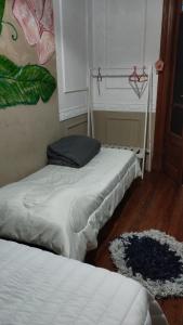 a bedroom with two beds and a window and a rug at Dante y compañia in Buenos Aires