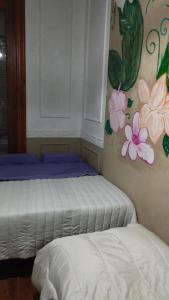 two beds in a room with flowers on the wall at Dante y compañia in Buenos Aires