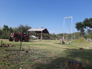 a red tractor parked in a field with a tent at Vedic Farms in Garhshankar