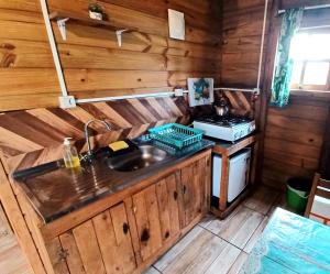 eine Küche mit einer Spüle und einem Herd in der Unterkunft Chalé Tribos Livres in Torres