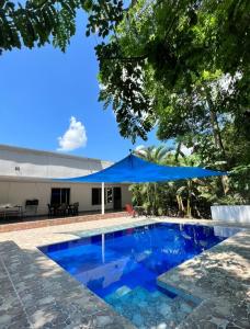 una piscina azul con sombrilla azul en Casa Quinta Murcia, en Carmen de Apicalá