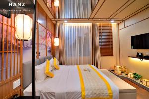 1 dormitorio con 1 cama grande con almohadas amarillas en HANZ Friday Premium Hotel en Ho Chi Minh