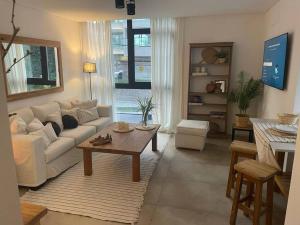 sala de estar con sofá blanco y mesa en Departamento Exclusivo Playa Grande en Mar del Plata