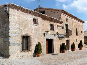 a stone building with potted plants in front of it at La Clerecia de Ledesma in Ledesma