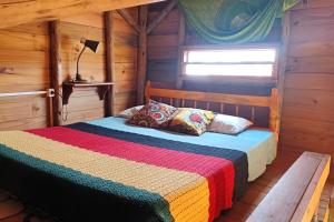 ein Schlafzimmer mit einem Bett in einer Holzhütte in der Unterkunft Chalé Tribos Livres in Torres