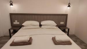 1 cama grande con 2 almohadas y 2 toallas en Nirili Villa, en Dhiffushi