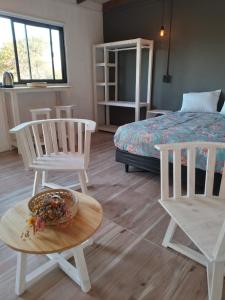 1 dormitorio con 2 sillas, 1 cama y 1 mesa en Dormis El Colibrí en Panaholma