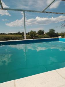 una piscina de agua con vistas a un campo en Dormis El Colibrí en Panaholma