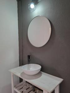 baño con lavabo y espejo en la pared en Dormis El Colibrí en Panaholma